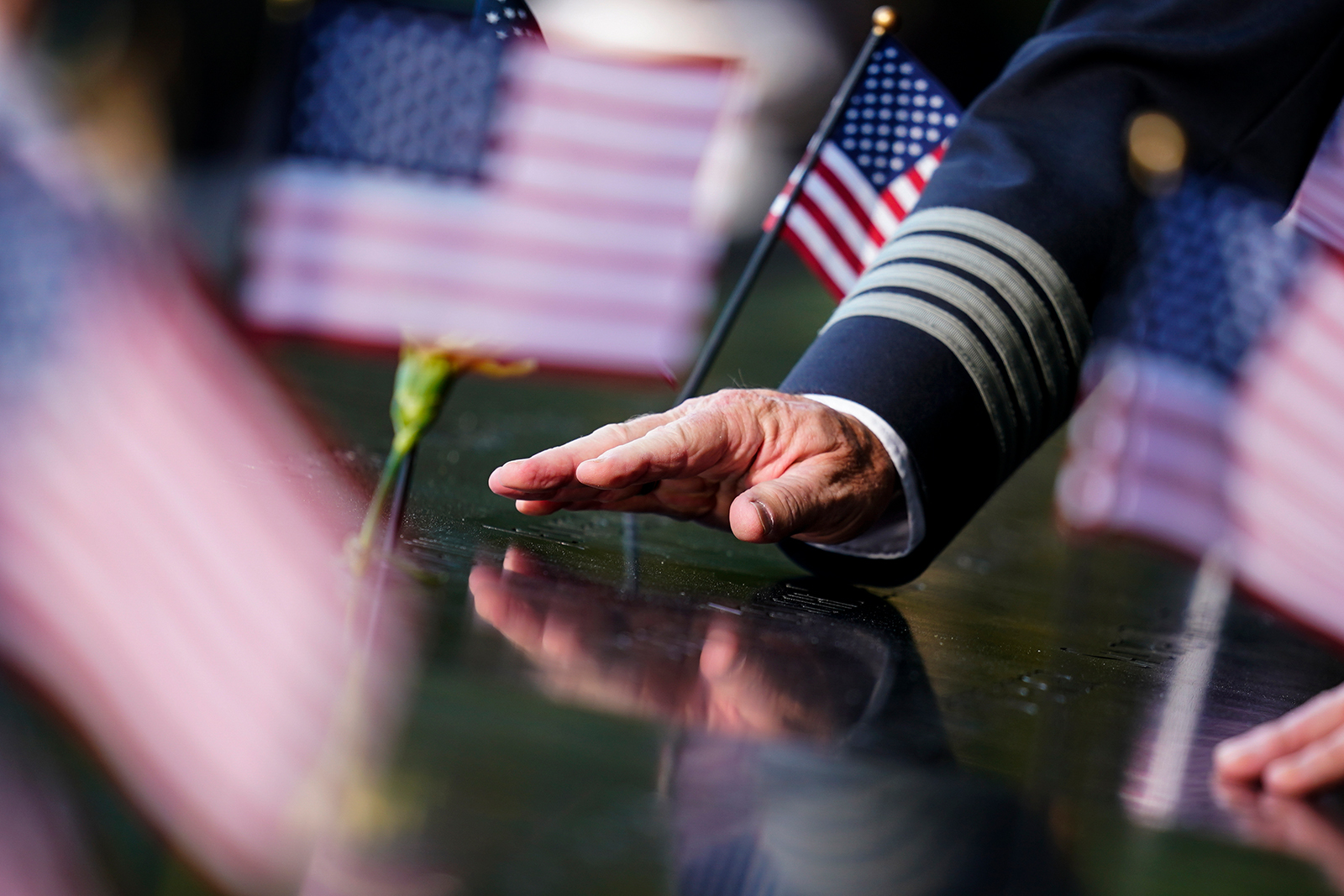 A person touches an inscribed name at the National September 11 Memorial and Museum ahead of the 20th anniversary of the 9/11 terrorist attacks, Friday, Sept. 10, 2021, in New York. (AP Photo/Matt Rourke)